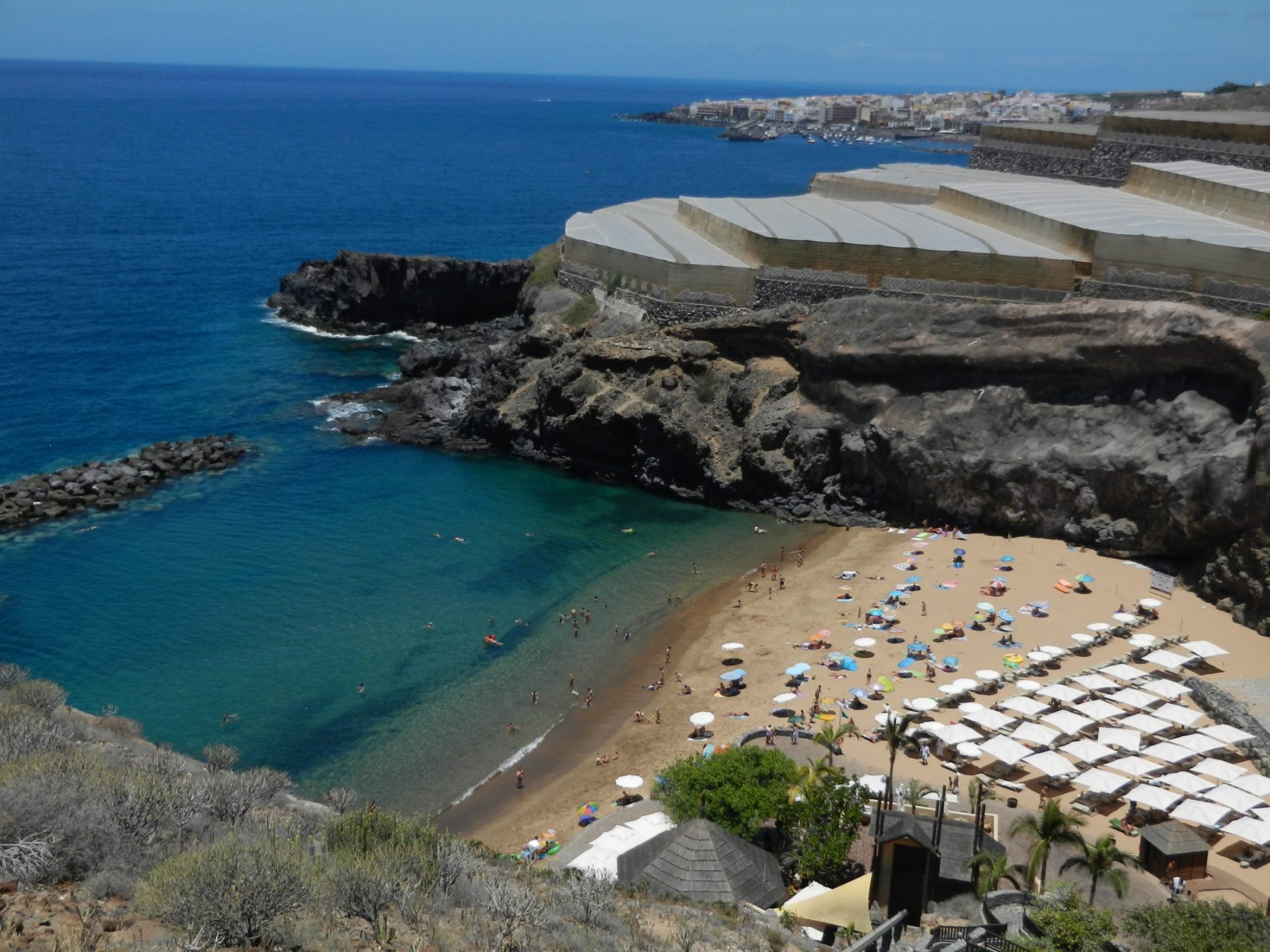 Die goldene Bucht der Playa de Abama mit ruhigem Wasser und Palmen
