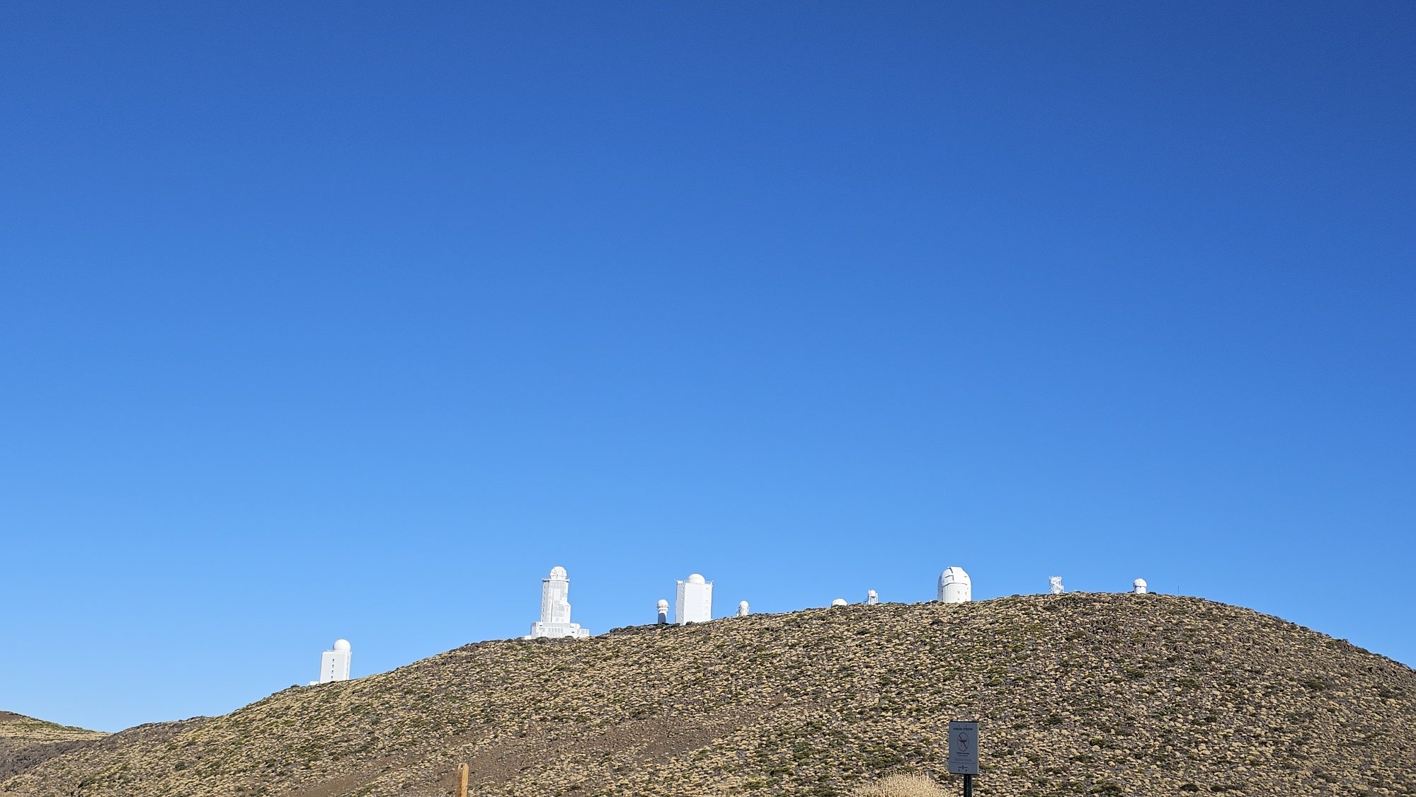 Weiße Kuppeln des astronomischen Observatoriums am Teide unter blauem Himmel